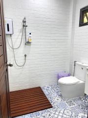 Modern bathroom with white brick-style tiles and blue patterned floor