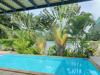 Bright outdoor area with swimming pool and lush greenery