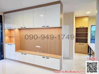 Modern kitchen with white cabinets, wooden accents, and bar stool