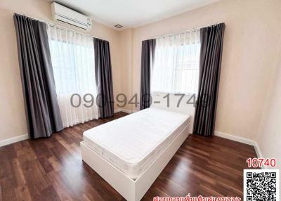 Spacious bedroom with air conditioning and hardwood flooring