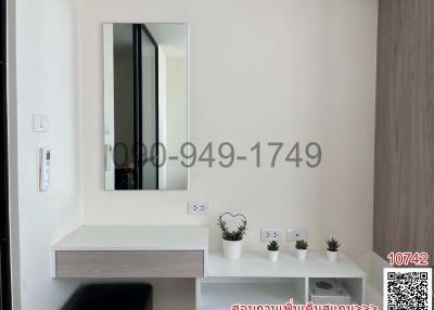 Modern hallway interior with wall-mounted shelf, decorative mirror, and small plants