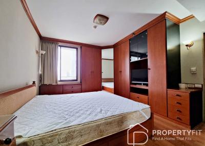 Spacious bedroom with large bed, built-in wardrobes, and dresser