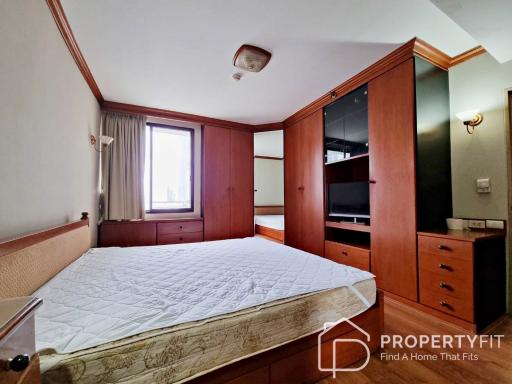 Spacious bedroom with large bed, built-in wardrobes, and dresser