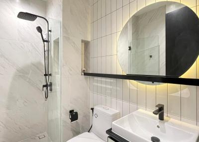 Modern bathroom interior with marble tiles and black accents