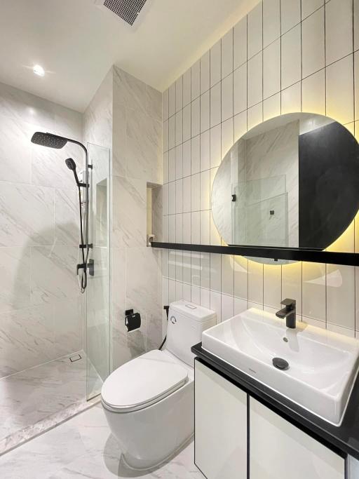 Modern bathroom interior with marble tiles and black accents