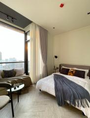 Modern bedroom with a view, featuring a large bed, floor-to-ceiling window, and tasteful decor