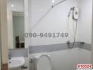 Modern white tiled bathroom with shower, toilet and sink