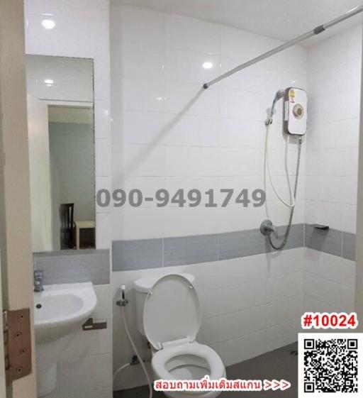 Modern white tiled bathroom with shower, toilet and sink