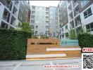 Exterior view of a modern apartment building entrance with greenery