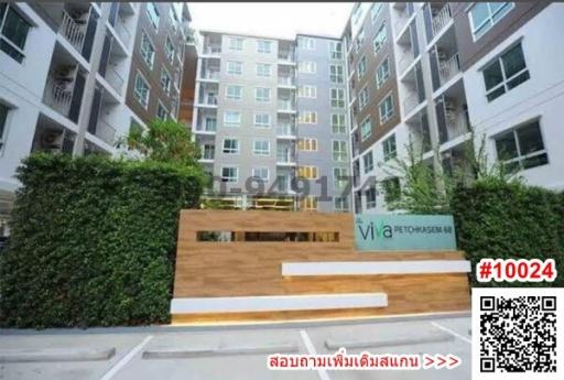 Exterior view of a modern apartment building entrance with greenery