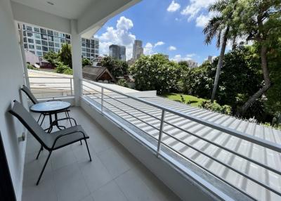 Spacious balcony with a view of the city and comfortable outdoor seating