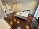 Spacious bedroom with hardwood floors and ample natural light