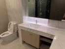 Modern bathroom interior with illuminated mirror and glass shower enclosure