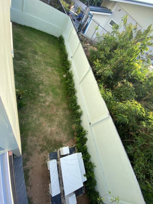 Small fenced backyard with lawn and pathway