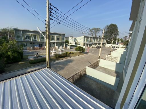 View from a balcony overlooking a residential area with townhouses and electrical lines