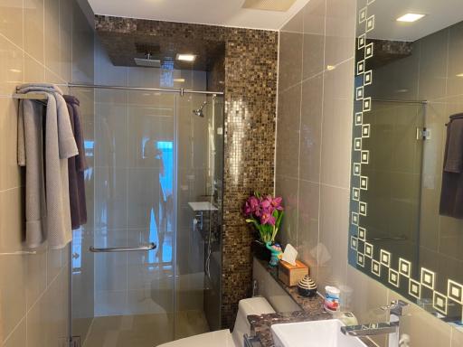 Modern bathroom interior with glass shower and decorative tiles