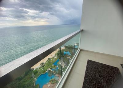 Spacious balcony overlooking the sea with a view of the pool area