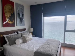 Modern bedroom with ocean view and artistic animal portraits