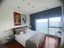 Spacious bedroom with ocean view, elegant decor, and natural light