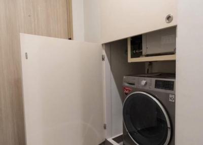 Compact laundry room with modern appliances and built-in cabinetry