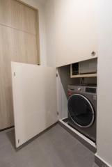 Compact laundry room with modern appliances and built-in cabinetry