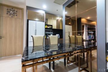 Modern dining area with marble table and kitchen in the background