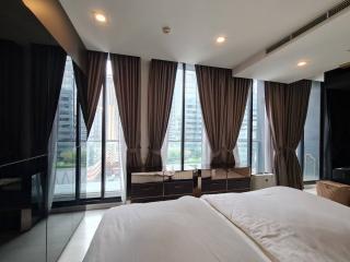 Spacious modern bedroom with large windows and city view