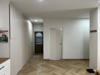 Spacious bedroom with hardwood flooring and white walls