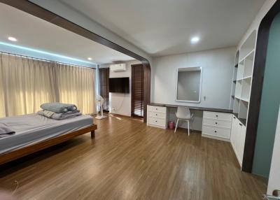 Spacious modern bedroom with large bed and ample shelving