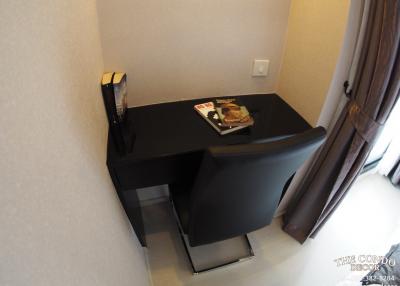 Compact bedroom workspace with dark-colored desk and chair