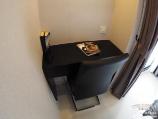 Compact bedroom workspace with dark-colored desk and chair