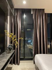 Modern bedroom interior with city view at night through large windows