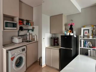 Compact modern kitchen with integrated appliances and white countertops