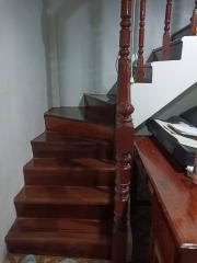 Wooden staircase with varnished balusters in a home interior