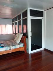 Cozy bedroom with wooden floor and large windows