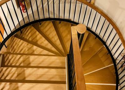 Elegant wooden spiral staircase with iron railings