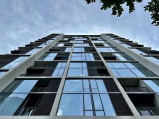 Low angle view of a modern high-rise residential building with blue sky