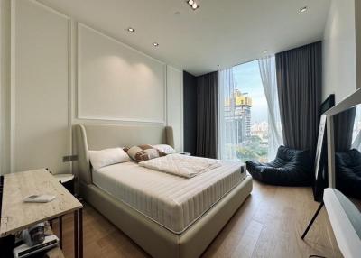 Modern bedroom with a king-size bed, large windows, and city view