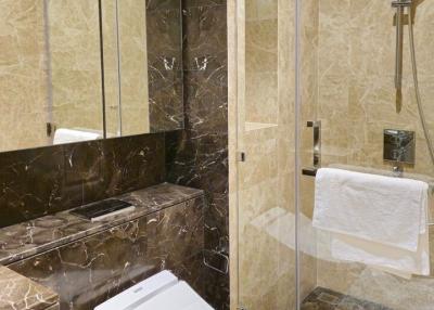 Modern bathroom with marbled tiles and glass shower enclosure