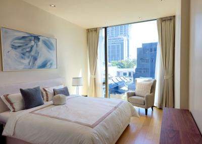 Bright bedroom with large windows and a city view