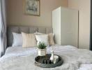 Cozy bedroom interior with neutral tones and decorative tray on bed