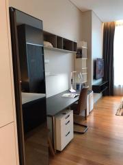 Modern bedroom with a workspace, shelving units, and parquet floor