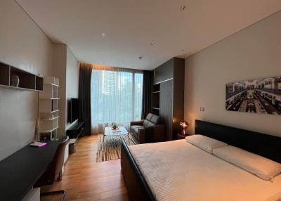 Modern bedroom with integrated living space, large window, and ample lighting