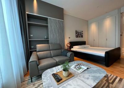 Modern bedroom with integrated living space featuring a comfortable sofa and marble coffee table