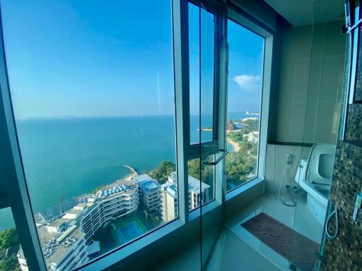 Modern bathroom with large window overlooking the beach