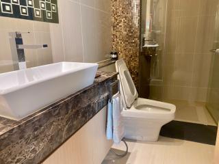 Modern bathroom with beige tiles and mosaic wall detail