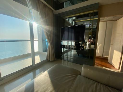 Modern living room with a view of the ocean, large windows, and ample sunlight