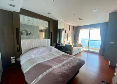 Spacious bedroom with large bed, natural light, and ocean view