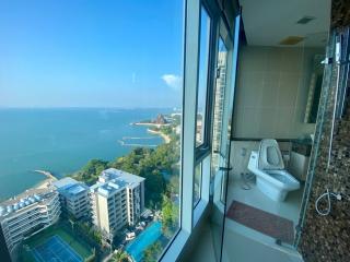 Modern bathroom with large window offering a panoramic sea view