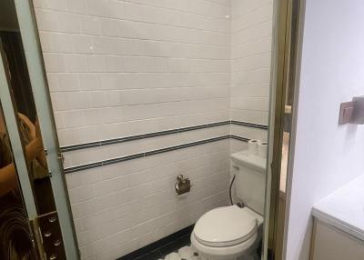 Compact bathroom with white tiles and glass shower door
